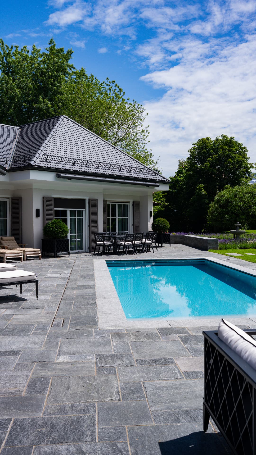 Pool mit Natursteinterrasse und Sonnenliegen