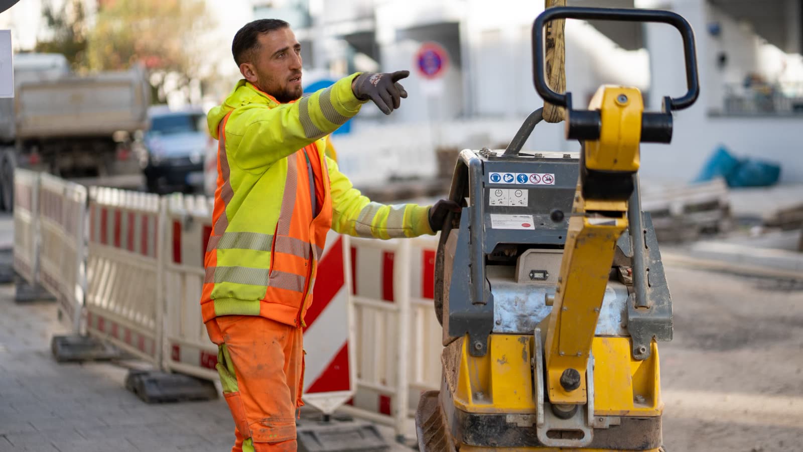 Einweisung auf der Baustelle neben einer Rüttelplatte