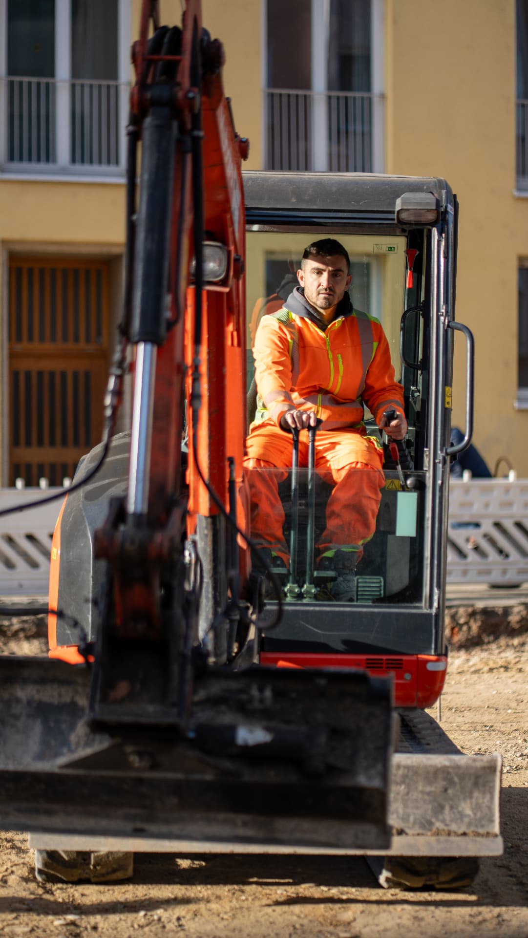 Mitarbeiter im Minibagger auf einer Baustelle in München