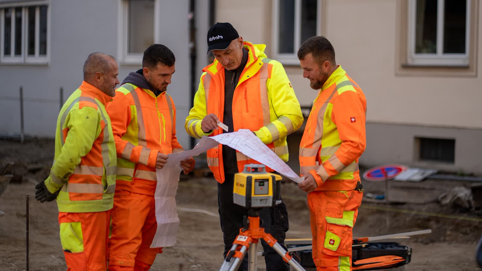 Bauteam von Sigi Baggerbetrieb bespricht einen Plan auf der Baustelle
